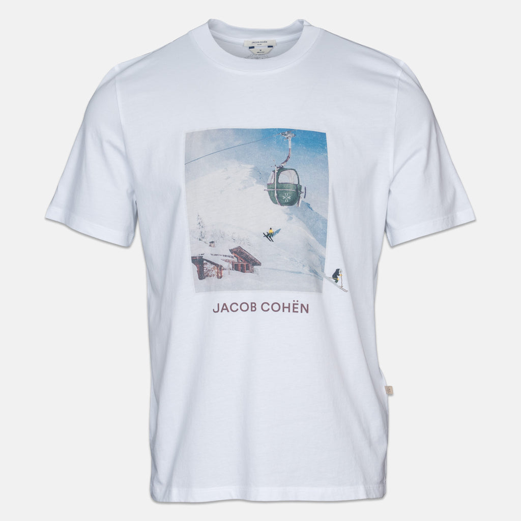 A white short-sleeve crewneck t-shirt featuring a square graphic print of a ski resort scene with a chairlift and the text 'JACOB COHÉN' printed below it. Jacob Cohen T-Shirt available at Sakks Menswear in Southampton.