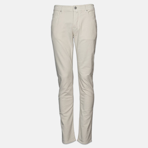 A pair of slim-fit, straight-leg jeans in a light cream or off-white color, displayed on a clean, light gray background. Jacob Cohen Jeans available at Sakks Menswear in Southampton.