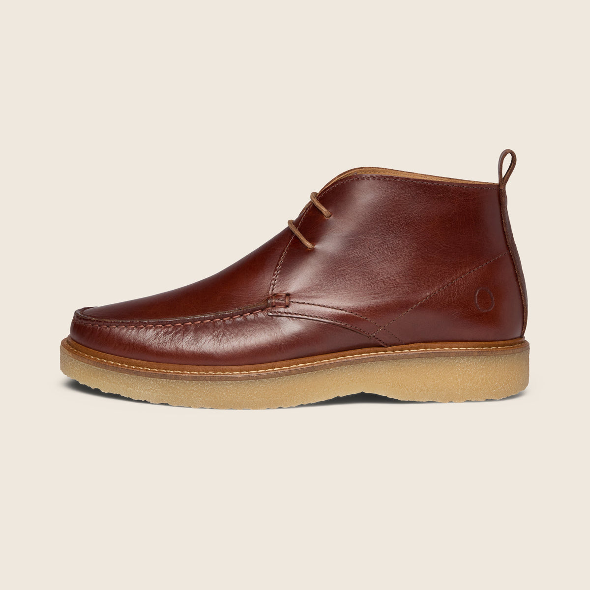 A brown leather chukka boot with a tan sole, shown in a side profile against a light beige background. Oliver Sweeney Moccasin Boots Available at Sakks Menswear in Southampton.