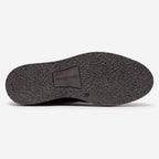 The textured black rubber outsole of a shoe, showing a central brand patch that reads 'Oliver Sweeney' on a clean white background. Oliver Sweeney Moccasin's available at Sakks Menswear in Southampton.