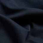 A close-up of dark navy blue fabric with soft folds and a fine ribbed texture. Oliver Sweeney T-Shirts available at Sakks Menswear in Southampton.