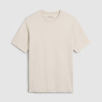 A light beige crewneck t-shirt with short sleeves, displayed flat against a light gray background. The brand name 'Oliver Sweeney' is visible in small script on the inner neck label. Oliver Sweeney T-Shirt available at Sakks Menswear in Southampton.