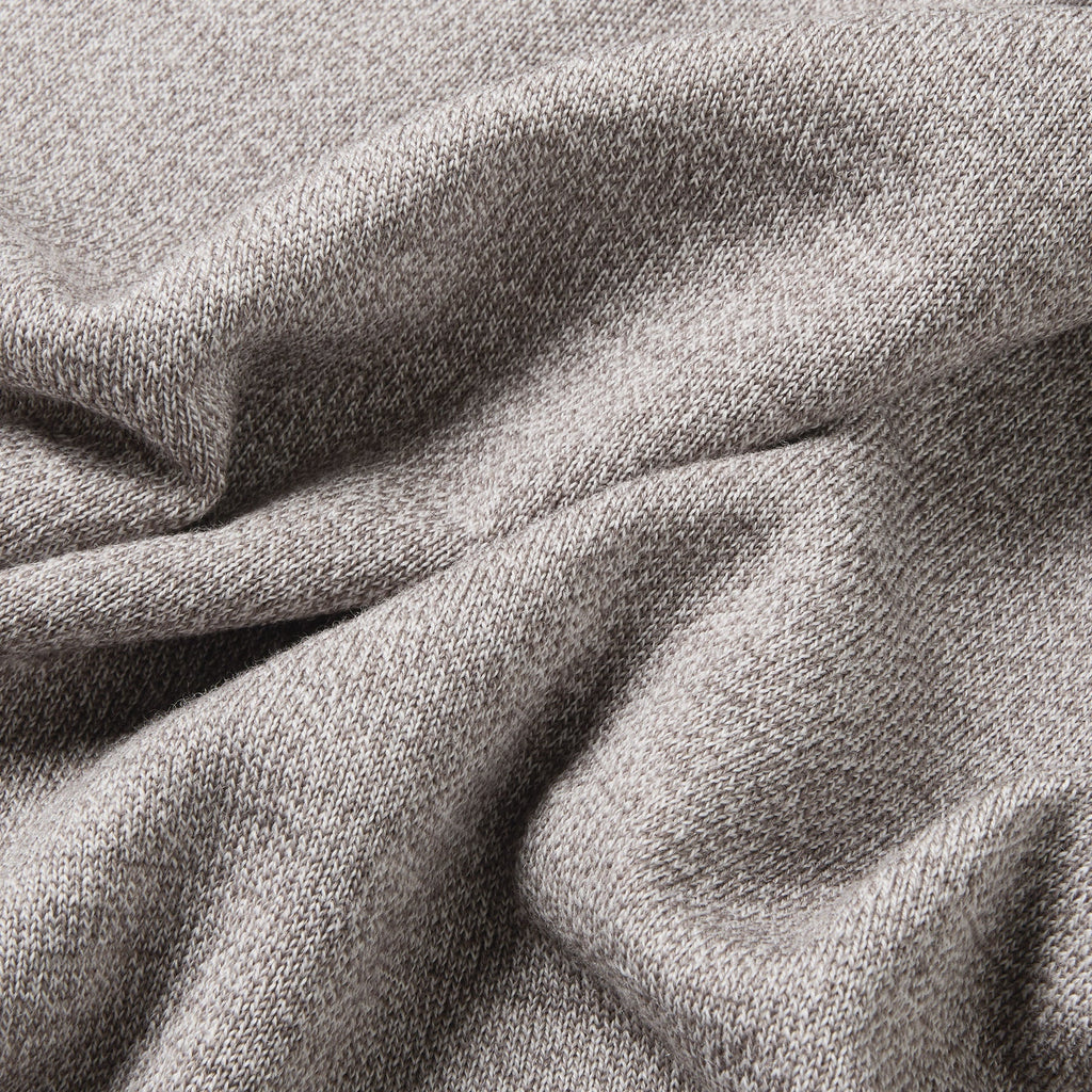 A close-up of draped heather gray fabric with a soft, woven texture filling the entire frame. Oliver Sweeney Sweater available at Sakks Menswear in Southampton.