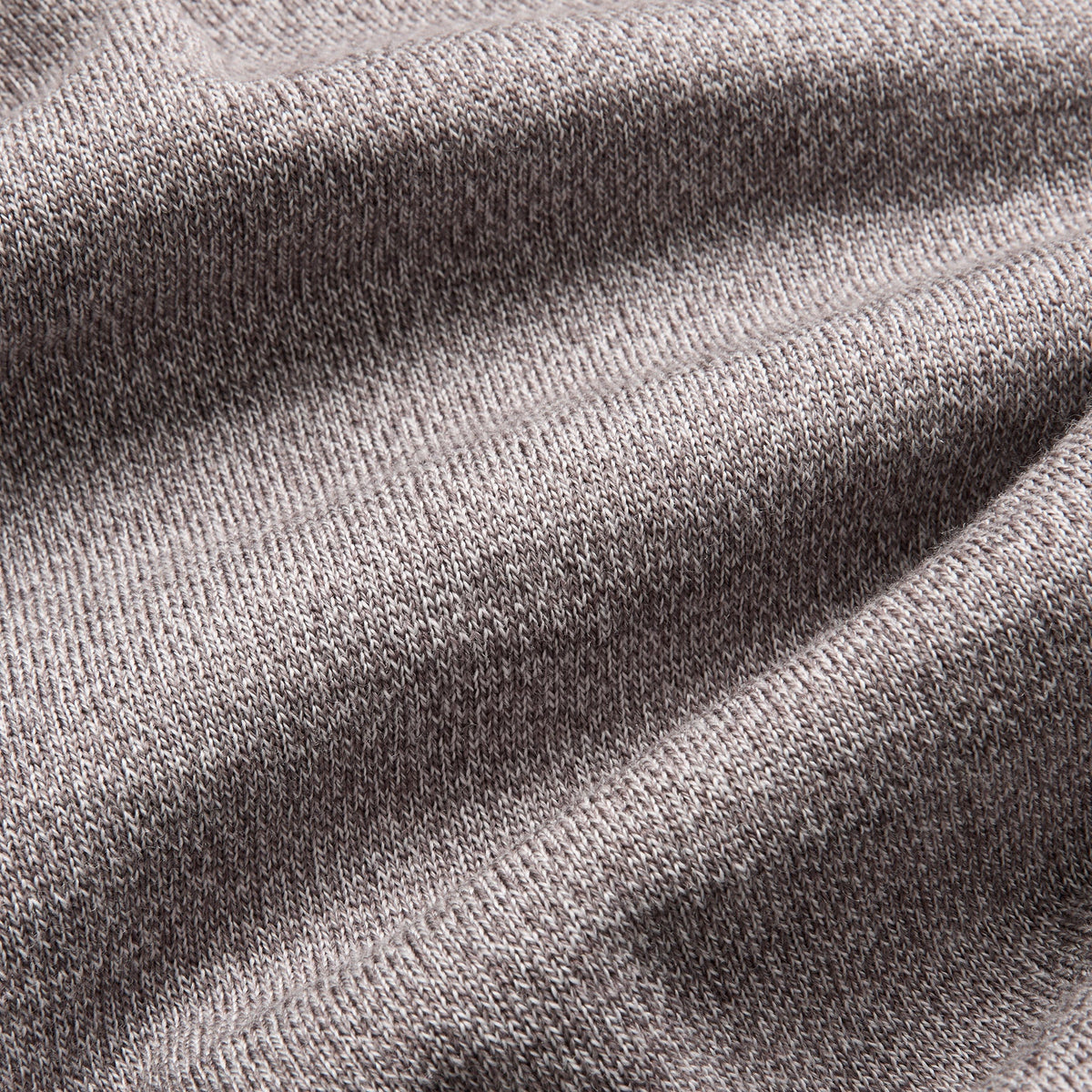 Close-up of a heather gray knit fabric texture with soft folds and visible woven detail. Oliver Sweeney Knitwear available at Sakks Menswear in Southampton.