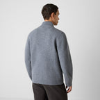 A man wearing a gray knit mock-neck sweater, shown from the back against a plain light gray studio background. Oliver Sweeney Cardigan available at Sakks Menswear in Southampton.