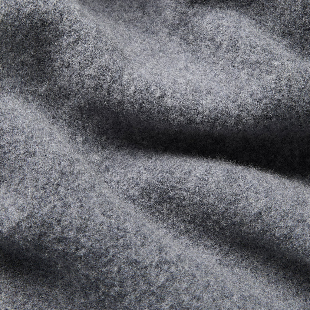 A close-up of textured gray fabric with soft folds and a heathered, slightly fuzzy surface. Oliver Sweeney Cardigan available at Sakks Menswear in Southampton.