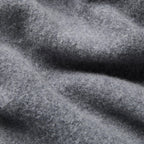 A close-up of textured gray fabric with soft folds and a heathered, slightly fuzzy surface. Oliver Sweeney Cardigan available at Sakks Menswear in Southampton.