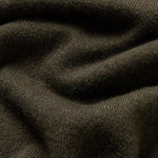 A close-up of dark olive green ribbed knit fabric with soft folds and shadows. Oliver Sweeney Knitwear available at Sakks Menswear in Southampton.