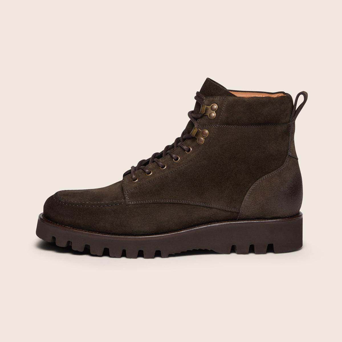 A dark brown suede lace-up ankle boot with a chunky lug sole, shown in a side profile on a light beige background. Oliver Sweeney Boots available at Sakks Menswear in Southampton.