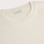 A close up of the crew neck collar of a Off-White Pima Cotton T-shirt placed in-front of a light grey background. Profuomo T-Shirts are available at Sakks Menswear in Southampton.