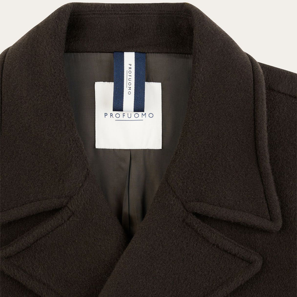Close-up of a dark brown wool coat collar with a white and navy blue interior label reading 'PROFUOMO'. Profuomo coat available at Sakks Menswear in Southampton.