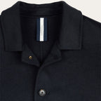 Close-up of a dark navy wool-blend polo shirt collar with a buttoned placket and a visible neck label reading PROFUOMO.  Profuomo Coat available at Sakks Menswear in Southampton.