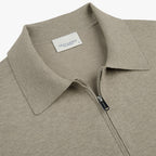 Close-up of a light taupe knit polo shirt with a collar and a partial zip closure, featuring a visible PROFUOMO brand label. Profuomo Polo available at Sakks Menswear in Southampton.