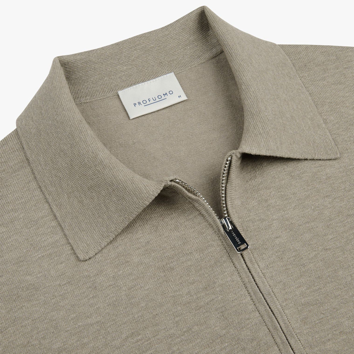 Close-up of a light taupe knit polo shirt with a collar and a partial zip closure, featuring a visible PROFUOMO brand label. Profuomo Polo available at Sakks Menswear in Southampton.