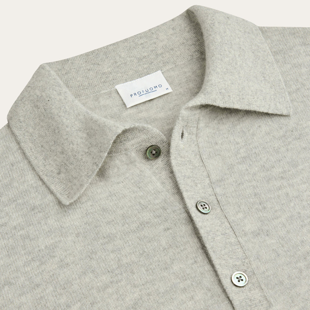 Close-up of a light heather gray knit polo shirt collar with green buttons and a visible PROFUOMO neck label. Profuomo Knitwear available at Sakks Menswear in Southampton.