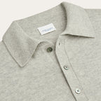 Close-up of a light heather gray knit polo shirt collar with green buttons and a visible PROFUOMO neck label. Profuomo Knitwear available at Sakks Menswear in Southampton.