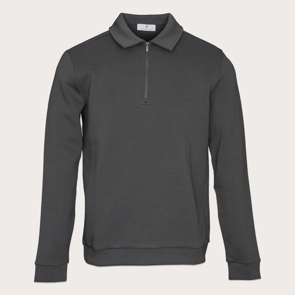 A dark gray long-sleeve quarter-zip pullover sweatshirt with a classic collar, displayed on a clean, light beige background. Thomas Maine Sweatshirt available at Sakks Menswear in Southampton.