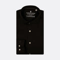A black long-sleeve dress shirt by Thomas Maine, neatly folded to show the collar, button placket, and left chest pocket with silver buttons, set against a light gray background. Thomas Maine Shirts available at Sakks Menswear in Southampton.
