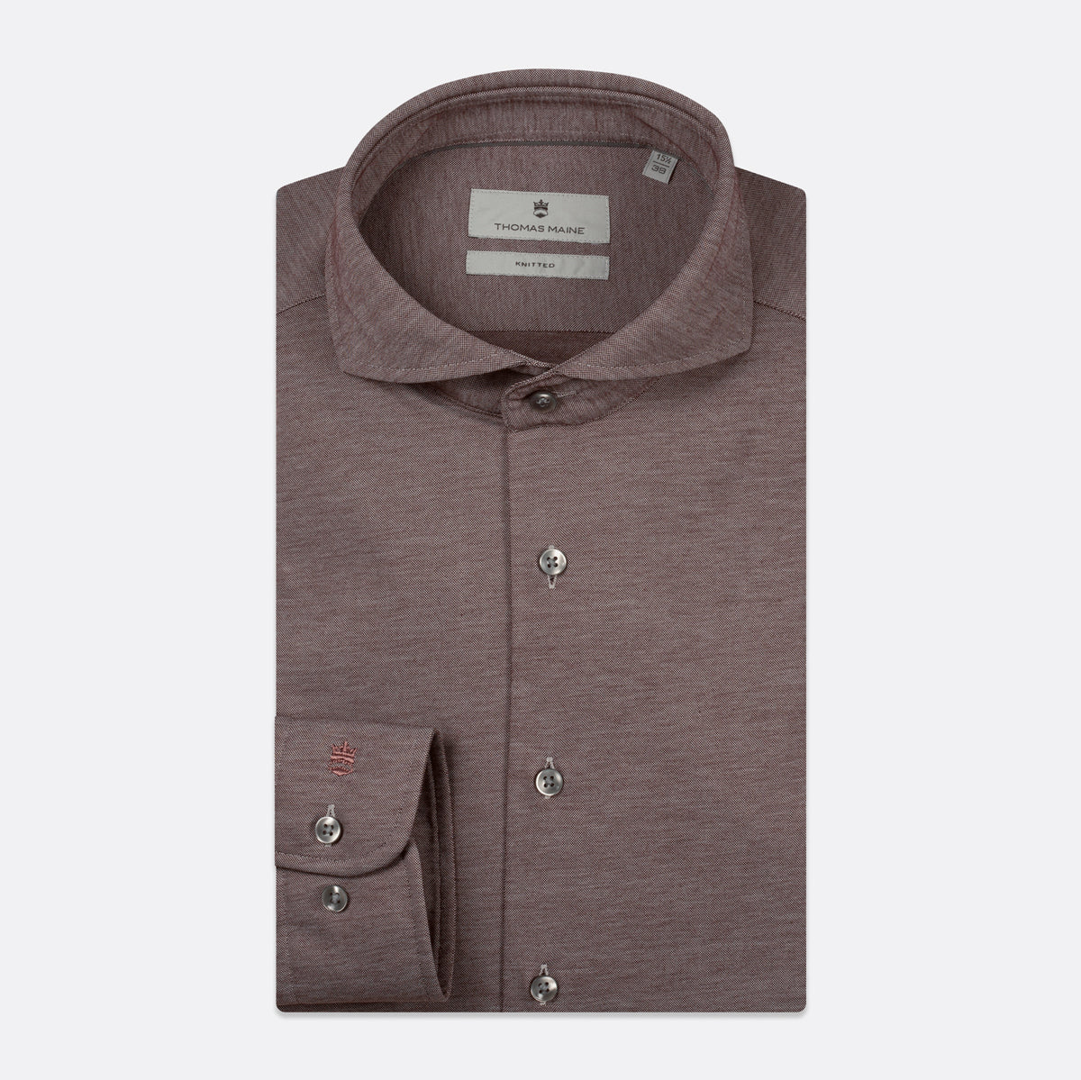 A folded men's dress shirt in a heathered dusty mauve-brown color, featuring a classic collar, button-down front, and a single-button cuff with a small embroidered red logo. The brand label inside the collar reads 'THOMAS MAINE'. Thomas Maine Shirts available at Sakks Menswear in Southampton.
