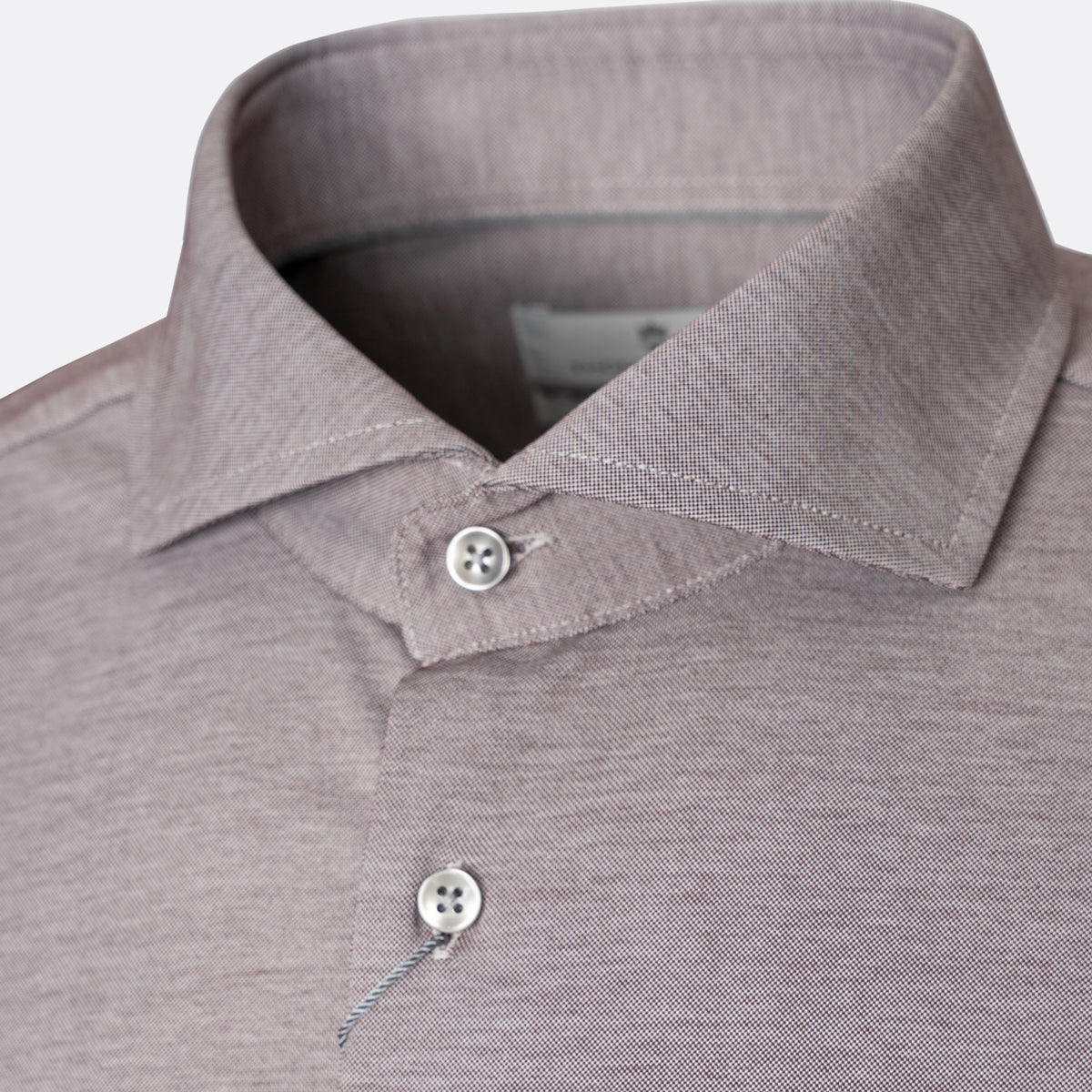 Close-up of a men's polo shirt collar and upper chest in a heathered taupe-gray fabric, featuring a buttoned placket and a small white brand label inside the collar. Thomas Maine Shirts available at Sakks Menswear in Southampton.