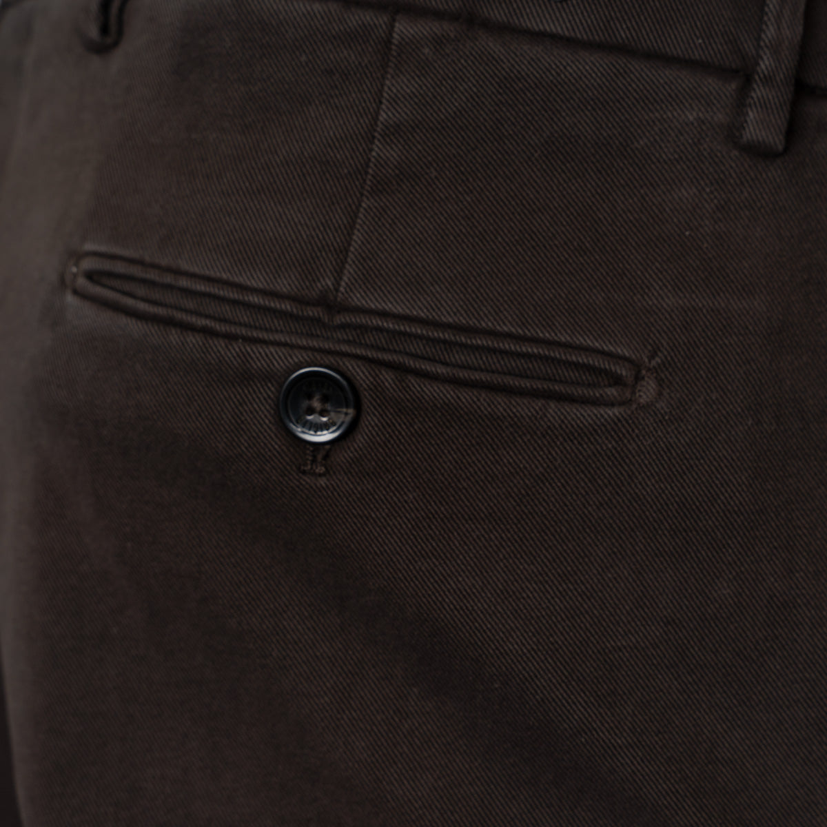 Close-up detail of dark brown trousers showing the back pocket with a button closure and the fabric texture. Briglia 1949 trousers available at Sakks Menswear in Southampton.