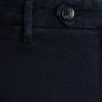 Close-up of dark navy blue denim fabric showing the texture, a belt loop, and a metal button with a visible G-100 brand logo. Briglia 1949 Trousers available at Sakks Menswear in Southampton.