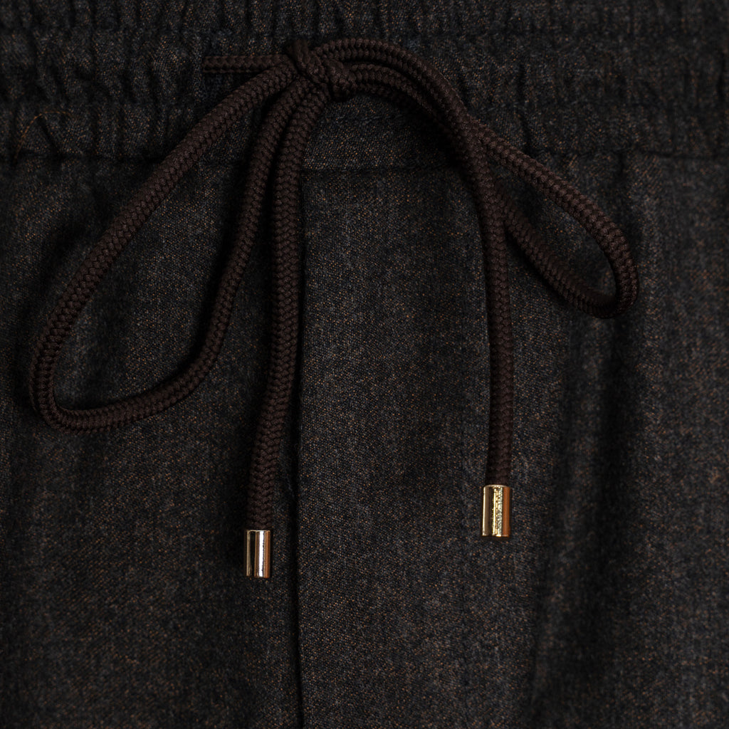 Close-up of dark charcoal gray textured fabric with a dark brown drawstring and small metallic gold end caps. Briglia 1949 Trousers available at Sakks Menswear in Southampton.