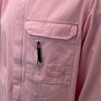 Close-up of a light pink long-sleeve shirt or jacket showing a chest pocket with a flap, a vertical zippered pocket with a black zipper pull, and a small hexagonal stitched pocket below. MA.Strum Shirt Jacket available at Sakks Menswear in Southampton.