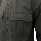 Close-up of an olive green utility jacket with a buttoned front and a large chest pocket. MA.Strum Shirt Jacket available at Sakks Menswear in Southampton.