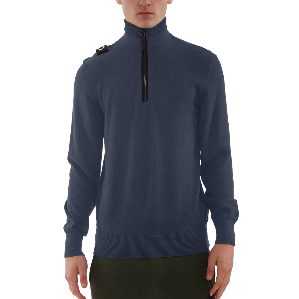 A man wearing a navy blue quarter-zip pullover sweater with a black zipper and a small black shoulder detail, shown against a plain white background. MA.Strum Knitwear available at Sakks Menswear in Southampton.