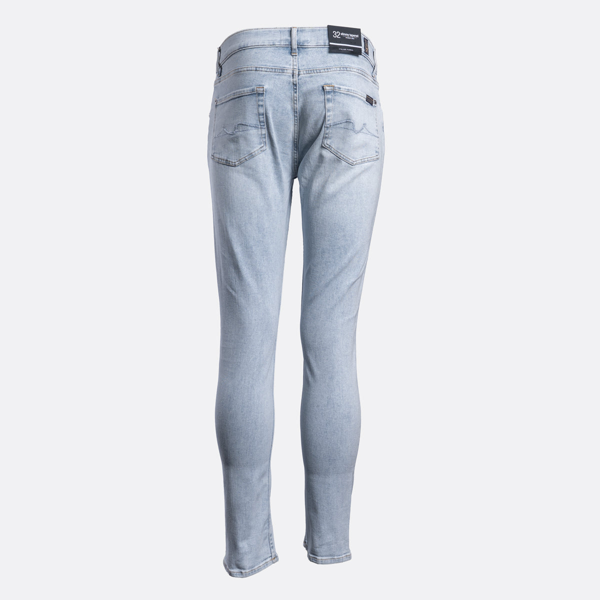 Light wash blue denim jeans shown from the back, featuring a slim-fit silhouette, classic five-pocket design, and a black brand patch on the back waistband. 7 For All Mankind Jeans available at Sakks Menswear in Southampton.