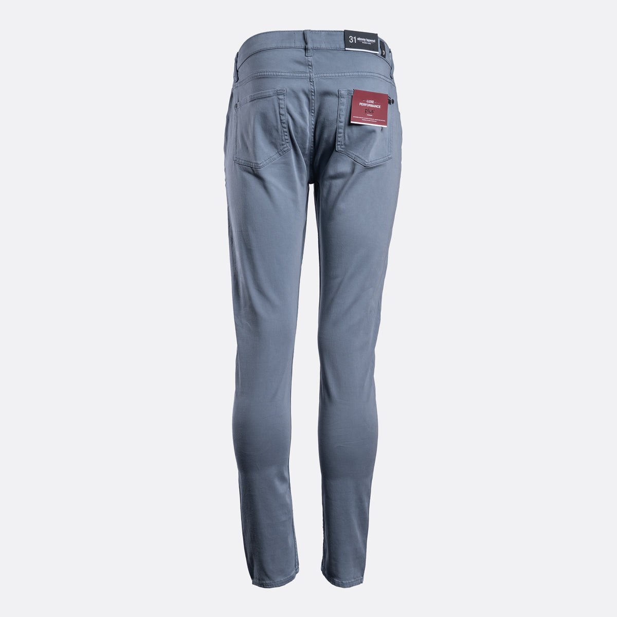 A pair of slim-fit blue jeans shown from the back, featuring a dark waistband patch and a red brand label on the right pocket, set against a plain light gray background. 7 For All Mankind Chinos available at Sakks Menswear in Southampton.
