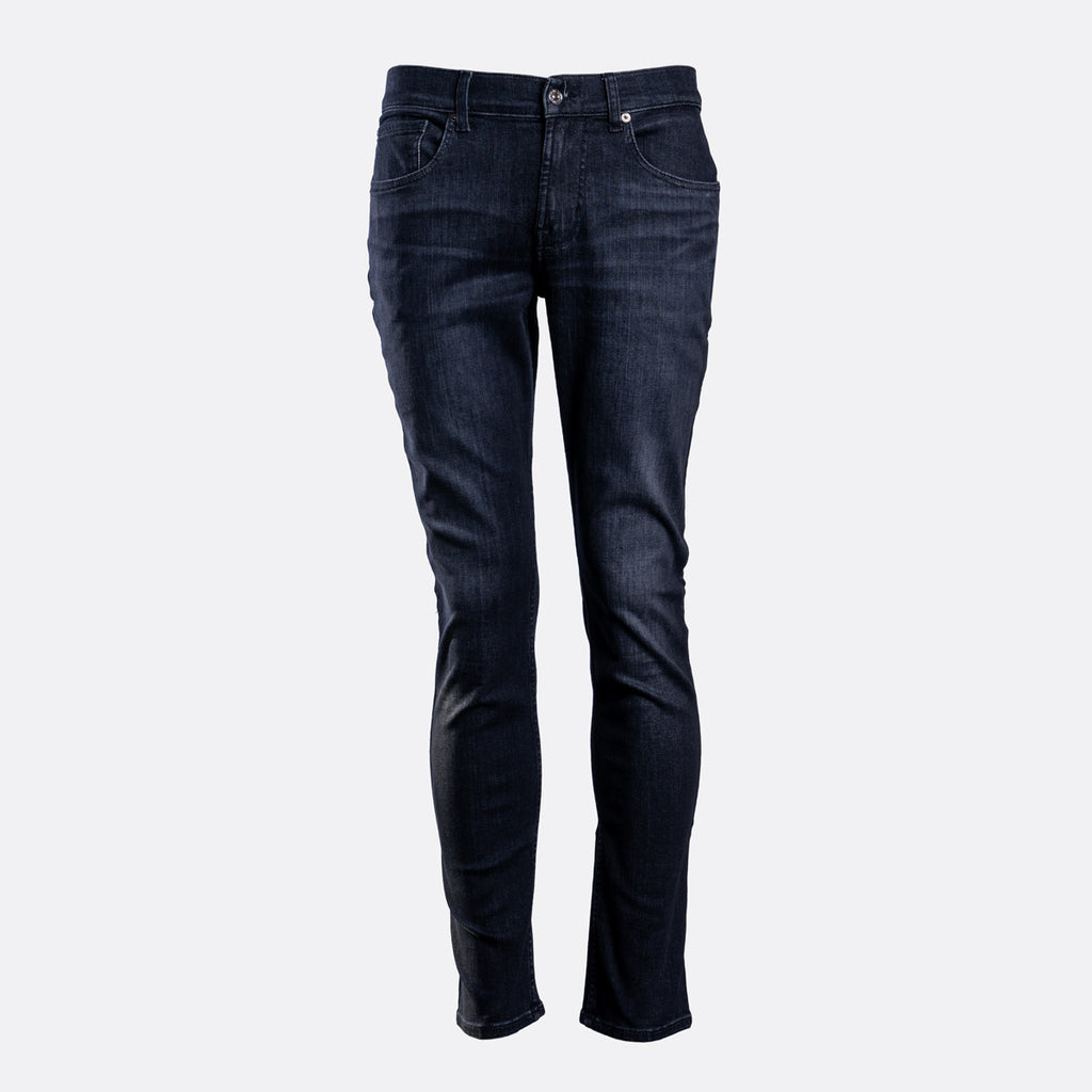 Dark navy blue slim-fit jeans shown on a headless mannequin against a light gray background. 7 For All Mankind Jeans available at Sakks Menswear in Southampton.