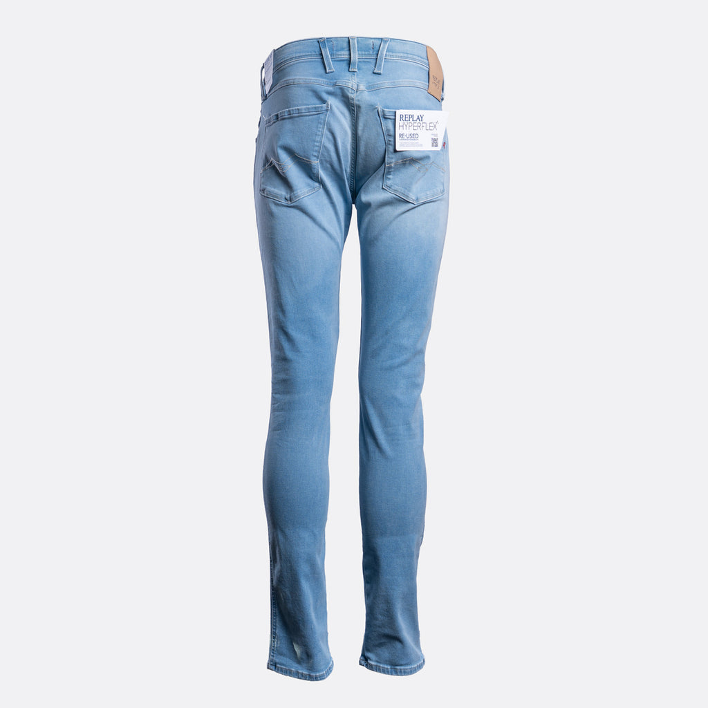 Light blue slim-fit jeans shown from the back, featuring a white brand label in the back pocket and a brown leather patch on the waistband, set against a plain light gray background. Replay Jeans available at Sakks Menswear in Southampton.