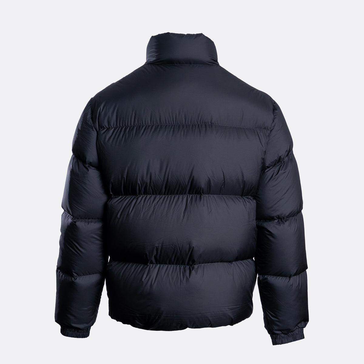 A dark navy blue puffer jacket shown from the back, featuring horizontal quilting and a high collar, set against a plain light gray background. Emporio Armani Down Jacket. Sakks Menswear Southampton.