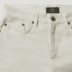 Close-up of a pair of light beige denim jeans showing the waistband, belt loops, front button closure, and pocket details. A black BELSTAFF label is visible at the top center. Belstaff Chino available at Sakks Menswear in Southampton.