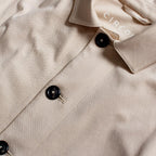Close-up of a beige button-up shirt with black buttons and a visible CIRCOLO brand label inside the collar. Circolo 1901 Shirt Jacket available at Sakks Menswear in Southampton.
