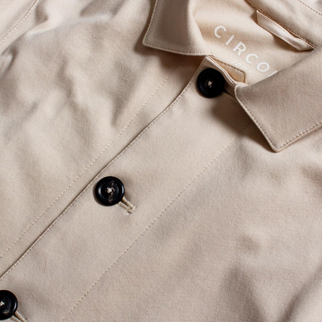 Close-up of a beige button-up shirt with black buttons and a visible CIRCOLO brand label inside the collar. Circolo 1901 Shirt Jacket available at Sakks Menswear in Southampton.