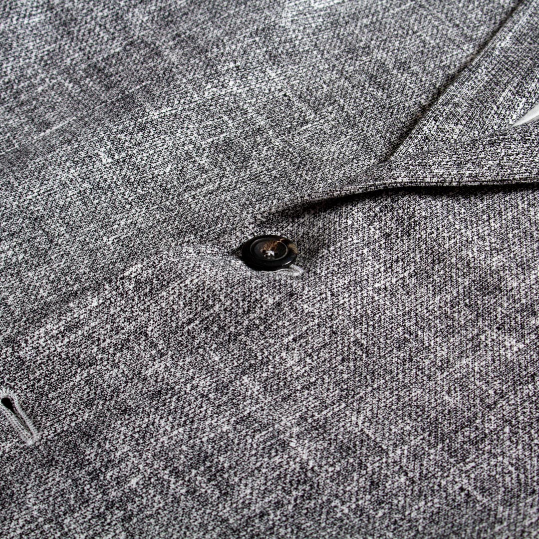 Close-up of a gray textured fabric with a dark button and part of a collar or lapel visible. Circolo 1901 Blazer available at Sakks Menswear in Southampton.