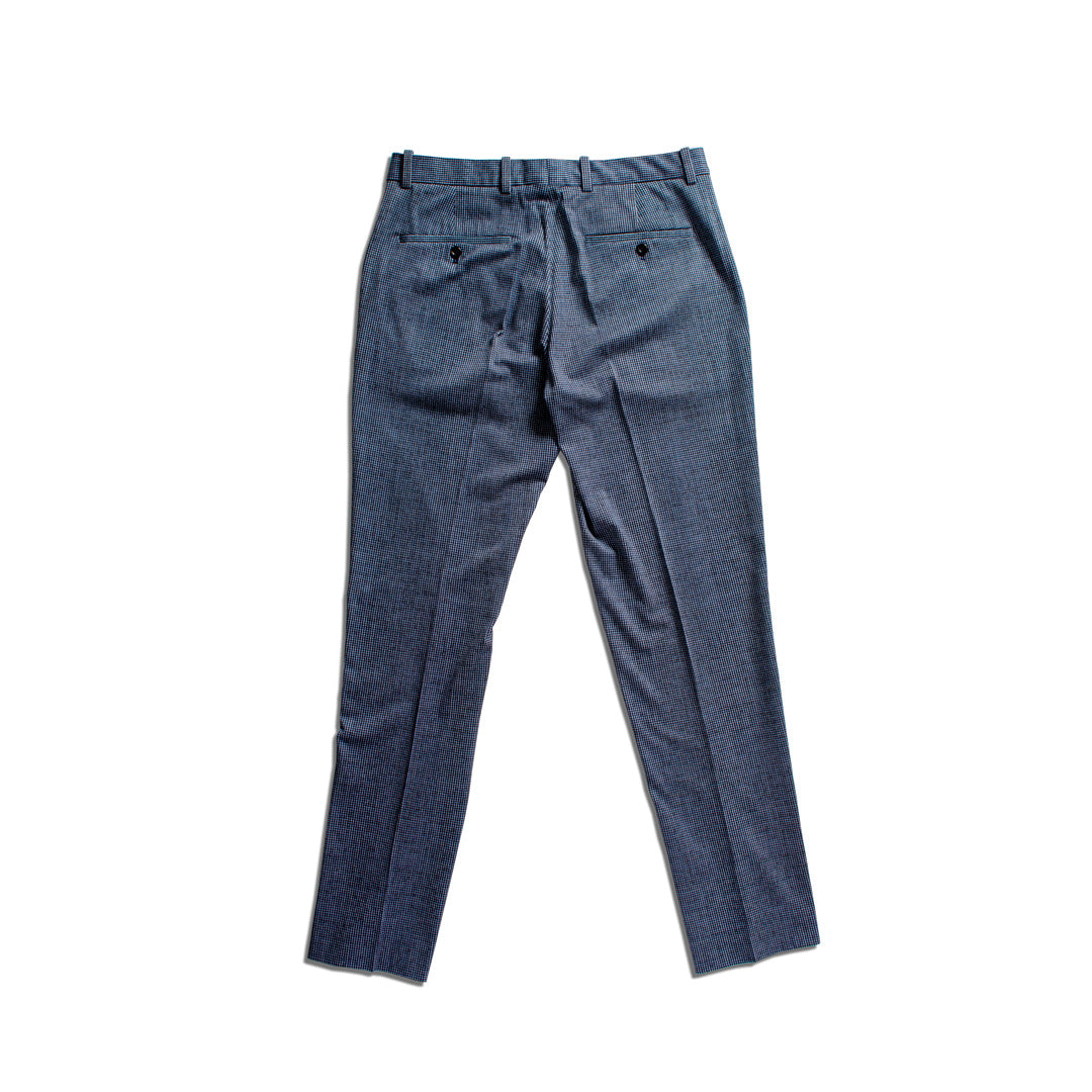 A pair of blue denim trousers shown from the back, featuring a pleated back, belt loops, and two buttoned welt pockets, laid flat on a white background. Circolo 1901 Trousers available at Sakks Menswear in Southampton.
