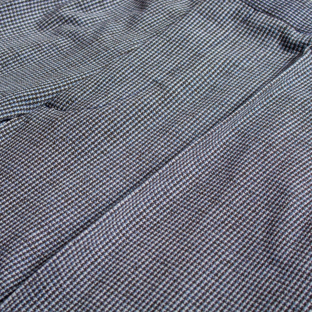 Close-up of a textured woven fabric with a fine micro-check pattern in gray, black, and subtle blue tones. Circolo 1901 Trousers available at Sakks Menswear in Southampton.