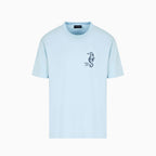 A light blue short-sleeve crewneck t-shirt with a small black seahorse graphic on the left chest, displayed on a clean white background. Emporio Armani T-Shirt. Sakks Menswear Southampton.