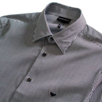 A close-up of a men's button-down shirt with a black and white micro stripe pattern, featuring a classic pointed collar and dark buttons. Emporio Armani Shirt. Sakks Menswear Southampton.
