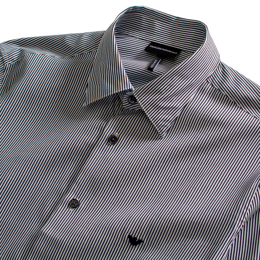 A close-up of a men's button-down shirt with a black and white micro stripe pattern, featuring a classic pointed collar and dark buttons. Emporio Armani Shirt. Sakks Menswear Southampton.