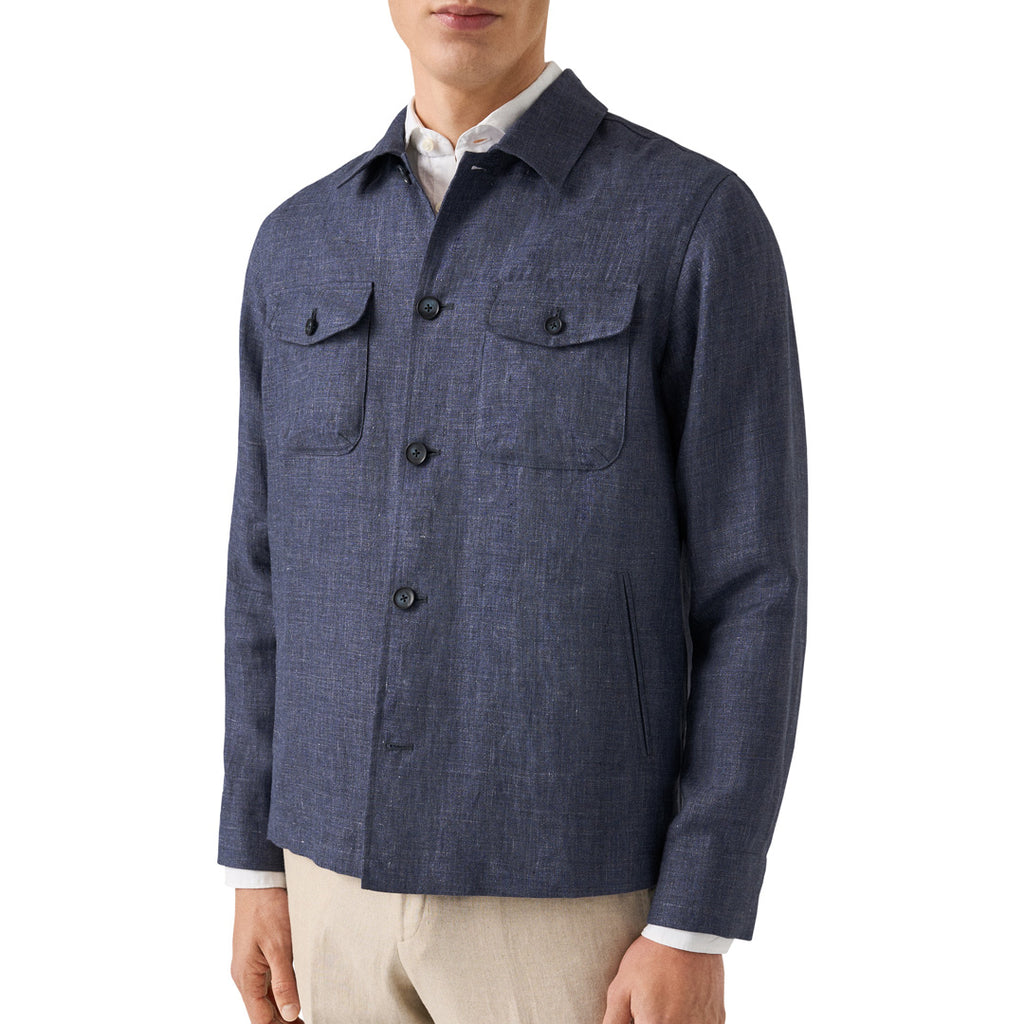 A man wearing a navy blue textured button-up shirt jacket over a white collared shirt and beige trousers, shown from the chin down against a plain white background. Eton Shirt Jacket available at Sakks Menswear in Southampton.