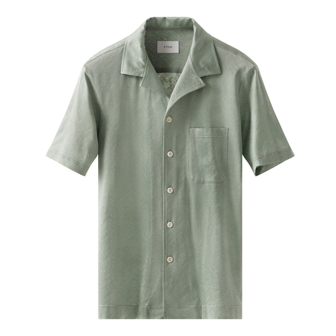 A light sage green short-sleeve button-up shirt with a collar, a chest pocket, and light-coloured buttons, shown against a plain white background. Eton Short Sleeve Shirt available at Sakks Menswear in Southampton.