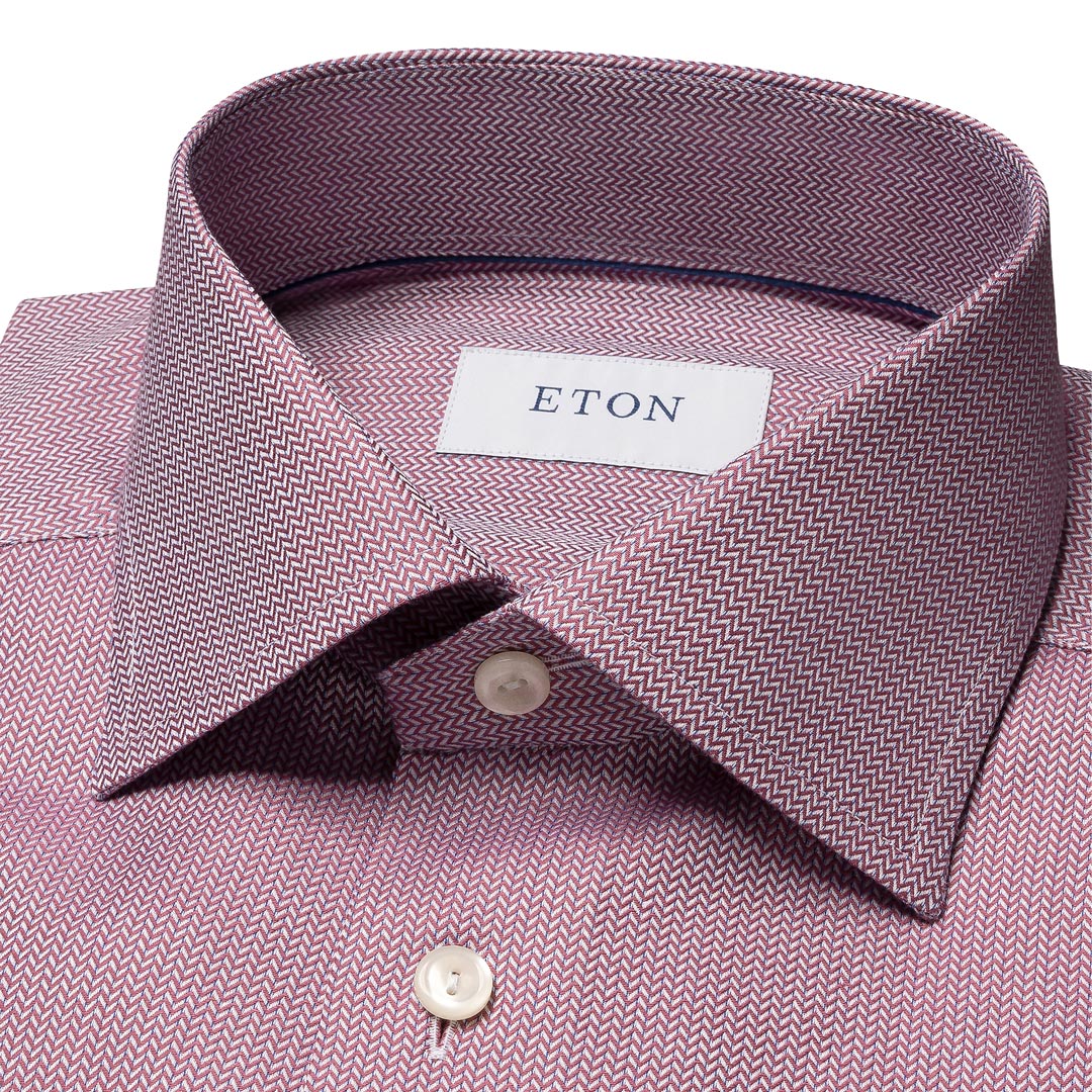 Close-up of a men's dress shirt collar in a dusty mauve pink and gray herringbone pattern, featuring a white neck label with the brand name ETON. Eton Shirt available at Sakks Menswear in Southampton.