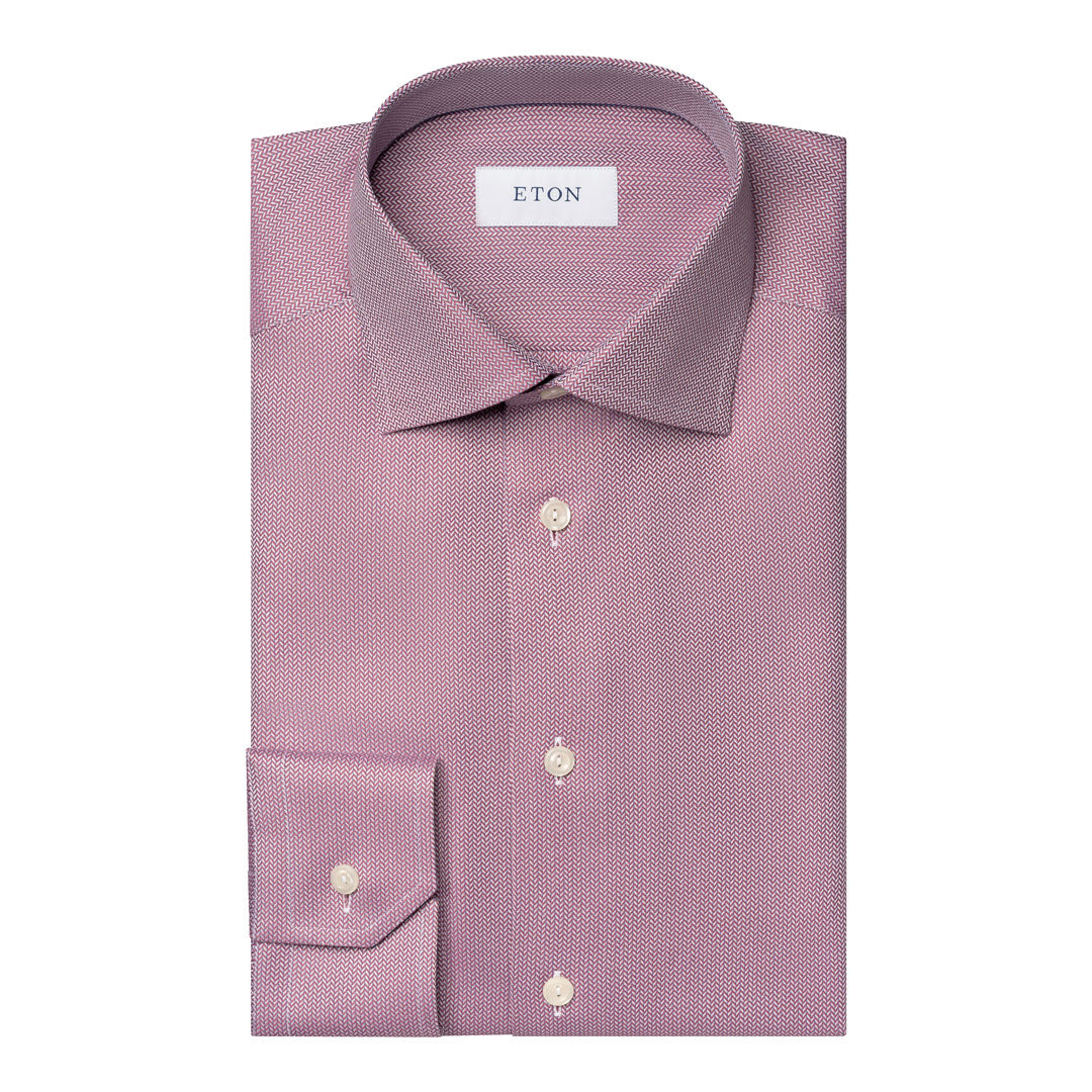 A folded ETON brand dress shirt in a dusty mauve-purple color with a subtle micro-texture, featuring a spread collar, button-down front, and a single-button cuff. Eton Shirt available at Sakks Menswear in Southampton.