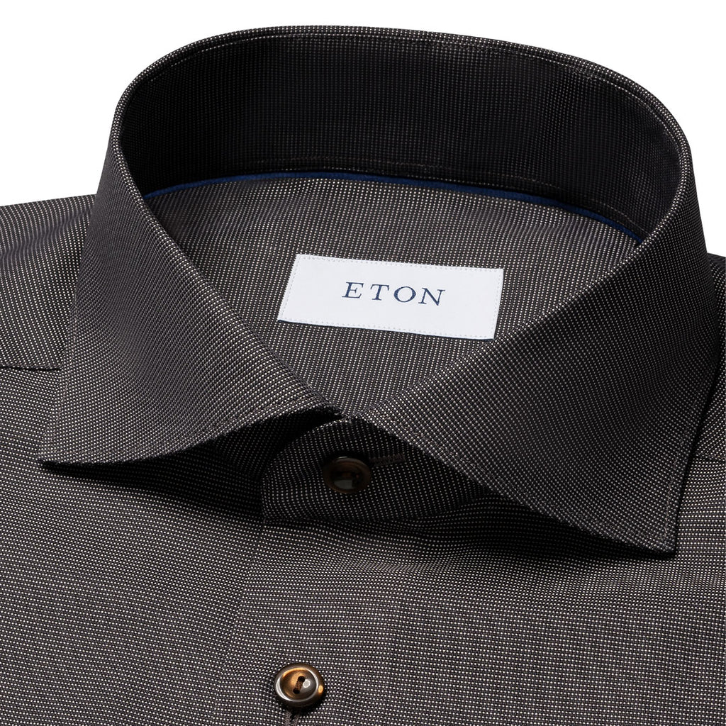Close-up of a dark charcoal gray textured dress shirt with a white neck label reading ETON. Eton Shirt available at Sakks Menswear in Southampton.