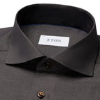 Close-up of a dark charcoal gray textured dress shirt with a white neck label reading ETON. Eton Shirt available at Sakks Menswear in Southampton.